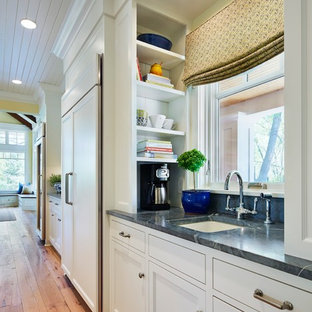 Стильный дизайн: параллельная кухня среднего размера в классическом стиле с врезной раковиной, кладовкой, фасадами в стиле шейкер, белыми фасадами, столешницей из талькохлорита, черным фартуком, фартуком из каменной плиты, белой техникой и светлым паркетным полом без острова - последний тренд