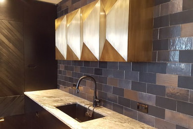 Example of a trendy single-wall home bar design in New York with flat-panel cabinets, dark wood cabinets, multicolored backsplash, stone tile backsplash and an undermount sink