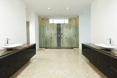 Alcove shower - huge modern master beige tile beige floor alcove shower idea in Orlando with flat-panel cabinets, dark wood cabinets, white walls, a vessel sink, granite countertops and a hinged shower door