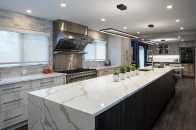 Example of a mid-sized trendy galley vinyl floor and gray floor eat-in kitchen design in Other with an undermount sink, flat-panel cabinets, white cabinets, solid surface countertops, white backsplash, subway tile backsplash, stainless steel appliances, an island and white countertops