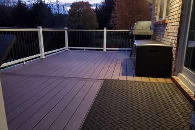 Inspiration for a mid-sized contemporary backyard mixed material railing deck remodel in Other with no cover