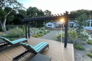 Huge mountain style backyard ground level deck photo in San Francisco with a pergola