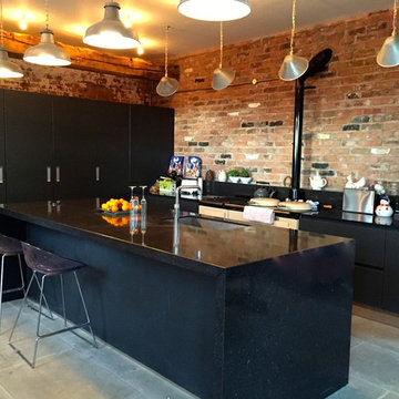 Next 125 Lava black matt glass and matt lacquer with Silestone Arden blue works