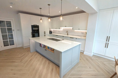 This is an example of a large contemporary l-shaped open plan kitchen in Hampshire with quartz worktops and an island.