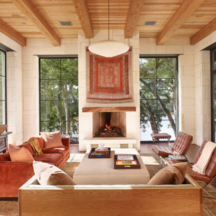 Example of a large tuscan formal and open concept brown floor, dark wood floor, exposed beam and wood ceiling living room design in Austin with white walls, a standard fireplace, a plaster fireplace and a tv stand