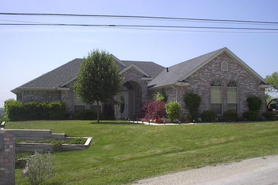 Large elegant multicolored one-story brick house exterior photo in Dallas with a gambrel roof and a shingle roof