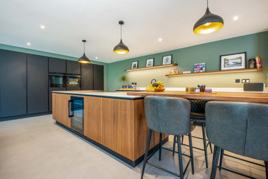 This is an example of a large modern kitchen in Sussex with black cabinets and an island.