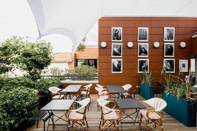 Exemple d'une terrasse moderne avec une cour et un auvent.