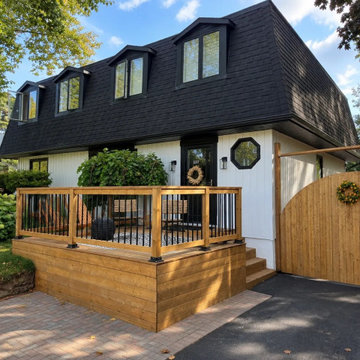 Raised pressure-treated front porch deck with black aluminum railing and a cedar