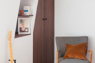 Réalisation d'un salon blanc et bois design de taille moyenne avec une bibliothèque ou un coin lecture, un sol en bois brun et boiseries.