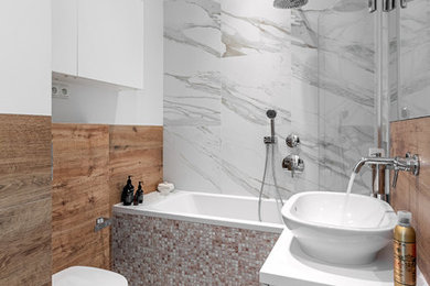 Inspiration for a small modern bathroom in Other with white cabinets, a drop-in tub, a shower/bathtub combo, a wall-mount toilet, beige tile, ceramic tile, beige walls, a wall-mount sink and engineered quartz benchtops.