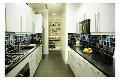 Trendy galley enclosed kitchen photo in Other with a drop-in sink, flat-panel cabinets, white cabinets, soapstone countertops, black backsplash and ceramic backsplash