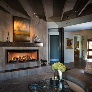 Modelo de salón para visitas cerrado, mediterráneo, grande, sin televisor, con suelo de pizarra, chimenea lineal, marco de chimenea de baldosas y/o azulejos, paredes grises y suelo gris