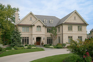 Inspiration for a large timeless beige two-story stone gable roof remodel in Chicago