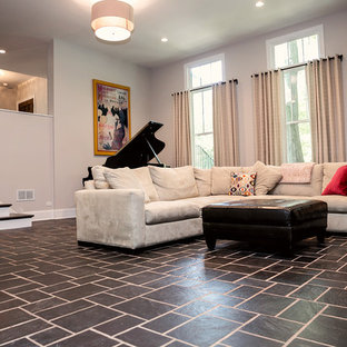 Exemple d'une grande salle de cinéma chic ouverte avec un mur gris, un sol en ardoise et un téléviseur encastré.