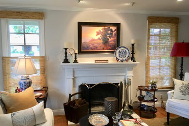Mid-sized transitional formal and open concept medium tone wood floor and brown floor living room photo in Orange County with gray walls, a standard fireplace, a wood fireplace surround and no tv