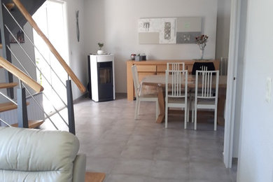 Aménagement d'une salle à manger ouverte sur le salon classique de taille moyenne avec un sol en carrelage de céramique, un sol gris, un mur gris et un poêle à bois.