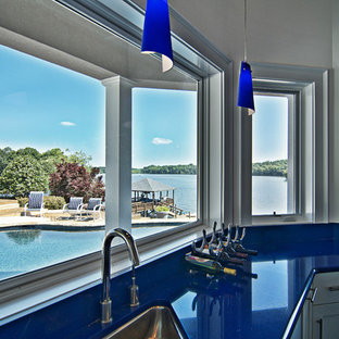 This is an example of a large contemporary u-shaped wet bar in Charlotte with travertine flooring, a submerged sink, shaker cabinets and white cabinets.