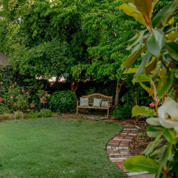 Backyard Garden with Brick Pathway, Bench, and Dogwood Canopy