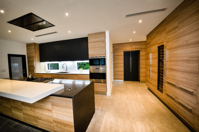 Photo of a mid-sized contemporary l-shaped separate kitchen in Miami with a single-bowl sink, flat-panel cabinets, medium wood cabinets, quartzite benchtops, white splashback, stone slab splashback, stainless steel appliances, with island and beige floor.