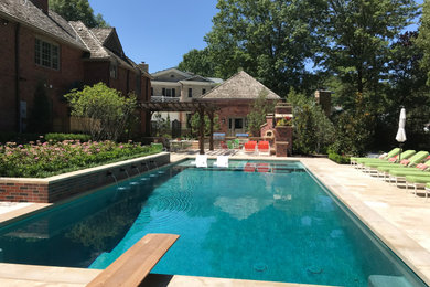 Example of a large classic backyard stone and rectangular pool design in Kansas City