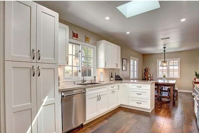 Mid-sized transitional galley dark wood floor eat-in kitchen photo in Los Angeles with shaker cabinets, white cabinets, no island, marble countertops, white backsplash, an undermount sink, subway tile backsplash and stainless steel appliances