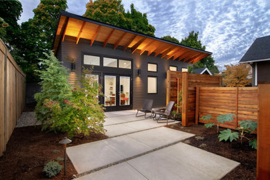 Patio - small contemporary front yard concrete patio idea in Other with a roof extension