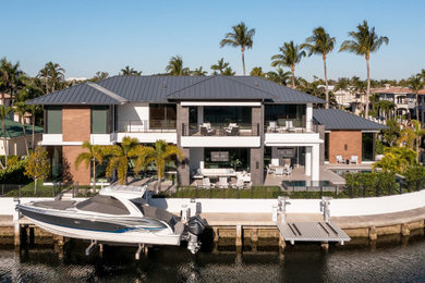 Huge trendy multicolored two-story mixed siding house exterior photo in Miami with a hip roof, a metal roof and a gray roof