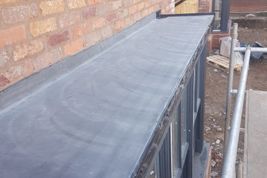 This is an example of a side detached house in West Midlands with a flat roof.