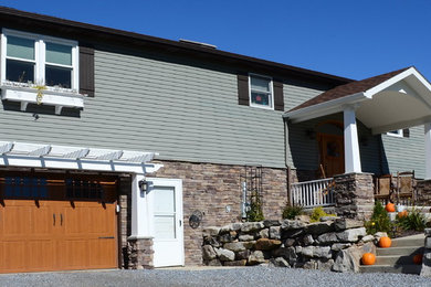 Mid-sized craftsman green two-story mixed siding exterior home idea in Other with a shingle roof