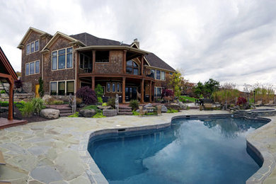 Large country backyard patio in Other with natural stone pavers and a gazebo/cabana.