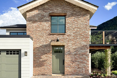 Farmhouse white brick house exterior idea with a mixed material roof