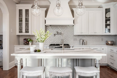 Inspiration for a large transitional l-shaped dark wood floor and brown floor eat-in kitchen remodel in Charlotte with an undermount sink, white cabinets, quartz countertops, gray backsplash, porcelain backsplash, stainless steel appliances, an island, white countertops and raised-panel cabinets