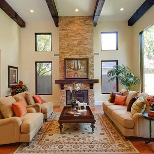 This is an example of a large mediterranean formal enclosed living room in Los Angeles with beige walls, terracotta flooring, a standard fireplace, a stone fireplace surround and no tv.