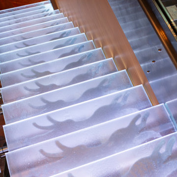 Glass private bar and glass stair treads inside a man cave in Michigan