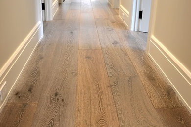 Large mountain style medium tone wood floor and brown floor hallway photo in New York with beige walls