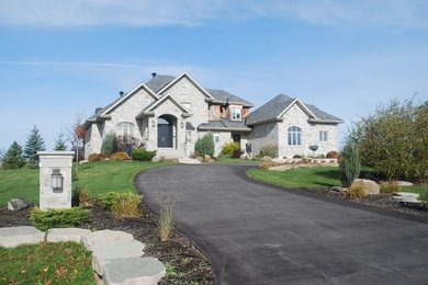 Mid-sized arts and crafts gray two-story stone house exterior photo in Other with a hip roof and a shingle roof
