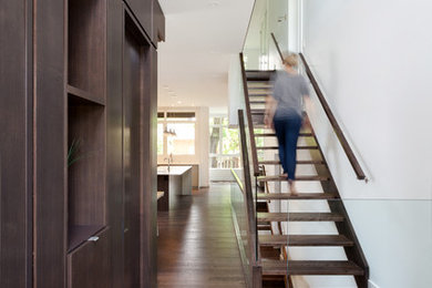 This is an example of a modern entryway in Ottawa with white walls and dark hardwood floors.