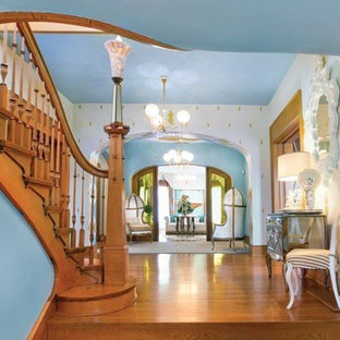 コロンバスの巨大なヴィクトリアン調のおしゃれな玄関 (マルチカラーの壁、淡色無垢フローリング) の写真