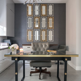 Bild på ett mellanstort funkis hemmabibliotek, med grå väggar, ett fristående skrivbord, grått golv och laminatgolv