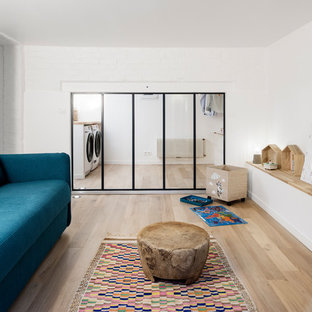 Inspiration for a large scandi look-out basement in Paris with white walls and light hardwood flooring.