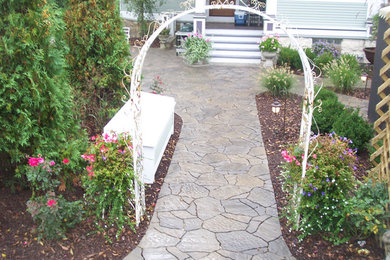 Inspiration for a mid-sized traditional front yard garden in Chicago with with path and natural stone pavers.