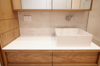 Mid-sized master bathroom in Sydney with furniture-like cabinets, medium wood cabinets, a double shower, a one-piece toilet, beige tile, ceramic tile, beige walls, cement tiles, a console sink, engineered quartz benchtops, beige floor, a hinged shower door, white benchtops, a shower seat, a single vanity and a freestanding vanity.