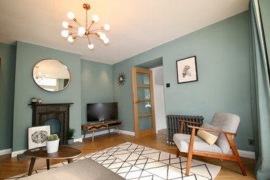 Design ideas for a large midcentury formal enclosed living room in Other with blue walls, laminate floors, a metal fireplace surround, a freestanding tv and beige floors.
