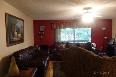 Example of a mid-sized eclectic open concept medium tone wood floor living room design in Tampa with red walls, no fireplace and a wall-mounted tv