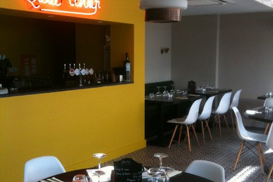 Aménagement d'une salle à manger rétro avec un mur jaune.