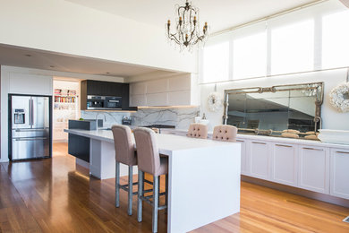 Design ideas for a large traditional l-shaped open plan kitchen in Central Coast with an undermount sink, shaker cabinets, white cabinets, quartz benchtops, white splashback, stone slab splashback, stainless steel appliances, light hardwood floors and with island.