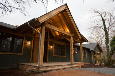 This is an example of a large rustic stone front porch design in Other with a roof extension.
