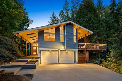 Inspiration for a large and blue midcentury two floor detached house in Seattle with wood cladding, a pitched roof, a shingle roof, a black roof and shiplap cladding.