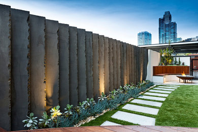 Inspiration for a mid-sized modern side yard garden in Melbourne with a garden path and natural stone pavers.